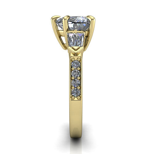 Audrey heart three stone engagement ring in 18K Yellow Gold, side profile showing the tapered baguette side stone and the round diamonds running down the shank