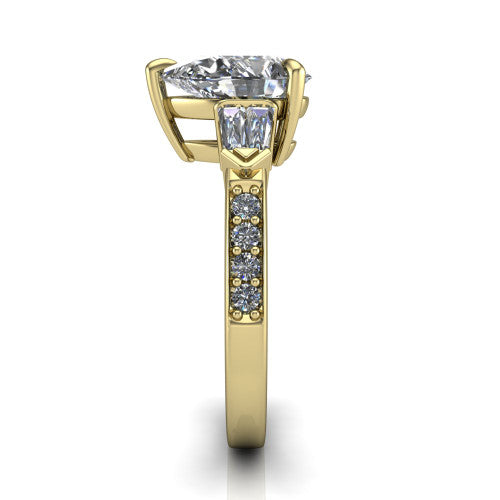 Audrey pear three stone engagement ring in 14K Yellow Gold, side profile showing the tapered baguette side stone and the round diamonds running down the shank