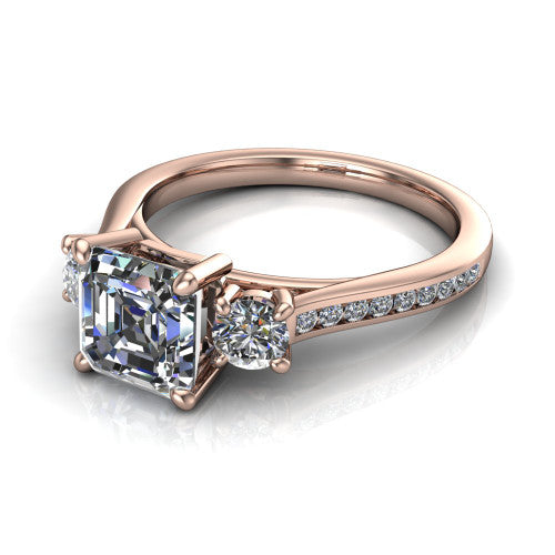 Saoirse asscher three stone engagement ring in 18K Rose Gold, three-quarter perspective showing the center diamond between two round side stones above a pav&eacute; shank