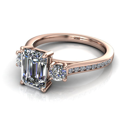Saoirse emerald three stone engagement ring in 14K Rose Gold, three-quarter perspective showing the center diamond between two round side stones above a pav&eacute; shank