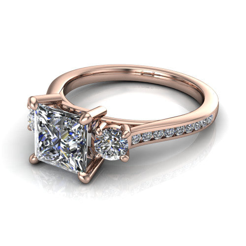 Saoirse princess three stone engagement ring in 14K Rose Gold, three-quarter perspective showing the center diamond between two round side stones above a pav&eacute; shank