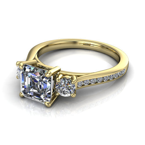 Saoirse asscher three stone engagement ring in 18K Yellow Gold, three-quarter perspective showing the center diamond between two round side stones above a pav&eacute; shank