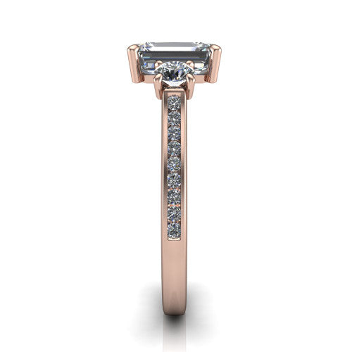 Saoirse emerald three stone engagement ring in 14K Rose Gold, side profile showing the round side stone and the pav&eacute; diamonds running down the shank