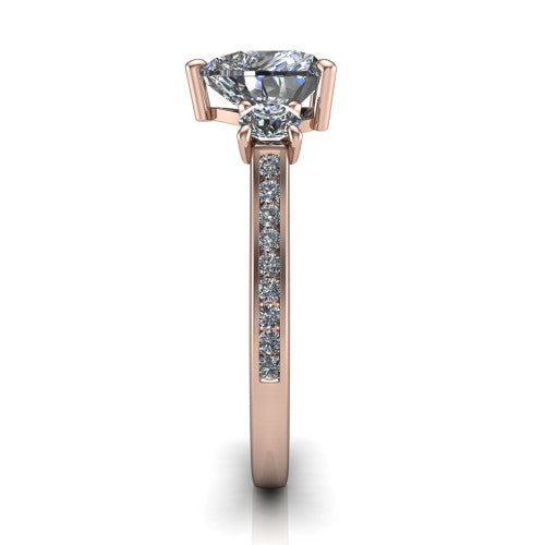 Saoirse heart three stone engagement ring in 18K Rose Gold, side profile showing the round side stone and the pav&eacute; diamonds running down the shank