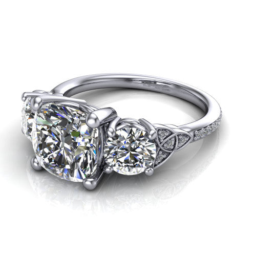 Zion cushion three stone engagement ring in 18K White Gold, three-quarter perspective showing the center diamond between two round side stones with Celtic trinity-knot shoulders above a pav&eacute; shank