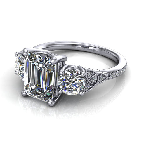 Zion emerald three stone engagement ring in Platinum, three-quarter perspective showing the center diamond between two round side stones with Celtic trinity-knot shoulders above a pav&eacute; shank