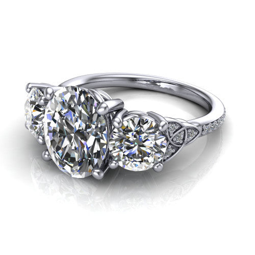 Zion oval three stone engagement ring in Platinum, three-quarter perspective showing the center diamond between two round side stones with Celtic trinity-knot shoulders above a pav&eacute; shank
