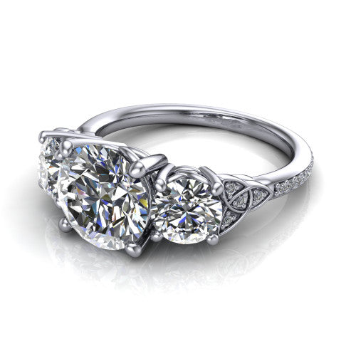 Zion round three stone engagement ring in Platinum, three-quarter perspective showing the center diamond between two round side stones with Celtic trinity-knot shoulders above a pav&eacute; shank