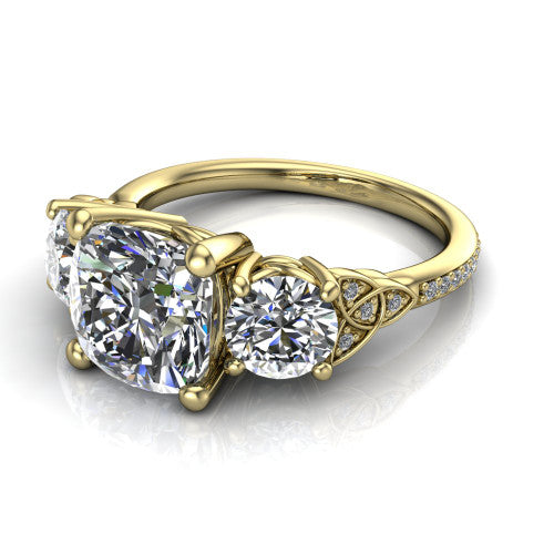 Zion cushion three stone engagement ring in 14K Yellow Gold, three-quarter perspective showing the center diamond between two round side stones with Celtic trinity-knot shoulders above a pav&eacute; shank