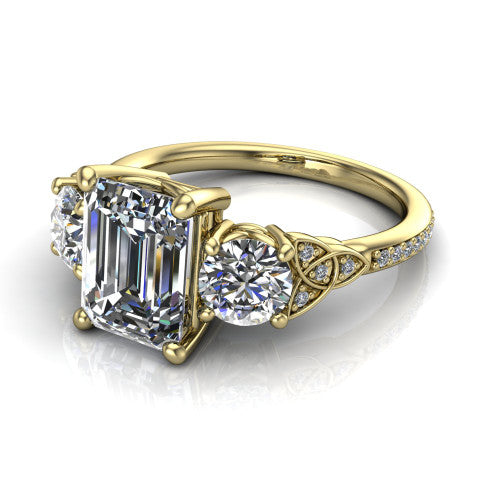 Zion emerald three stone engagement ring in 18K Yellow Gold, three-quarter perspective showing the center diamond between two round side stones with Celtic trinity-knot shoulders above a pav&eacute; shank