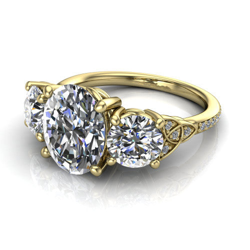 Zion oval three stone engagement ring in 14K Yellow Gold, three-quarter perspective showing the center diamond between two round side stones with Celtic trinity-knot shoulders above a pav&eacute; shank