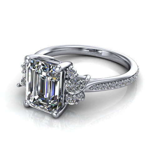 Mila emerald three stone engagement ring in 18K White Gold, three-quarter perspective showing the center diamond flanked by round accent clusters above a pav&eacute; shank