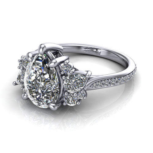 Mila pear three stone engagement ring in 18K White Gold, three-quarter perspective showing the center diamond flanked by round accent clusters above a pav&eacute; shank