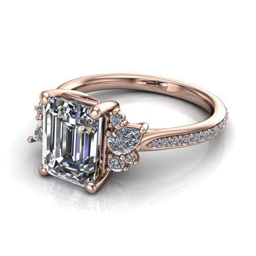 Mila emerald three stone engagement ring in 14K Rose Gold, three-quarter perspective showing the center diamond flanked by round accent clusters above a pav&eacute; shank