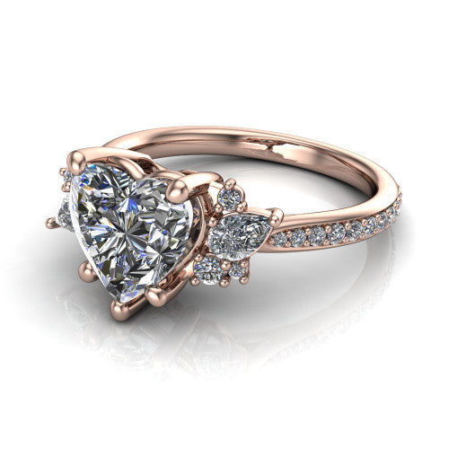Mila heart three stone engagement ring in 14K Rose Gold, three-quarter perspective showing the center diamond flanked by round accent clusters above a pav&eacute; shank