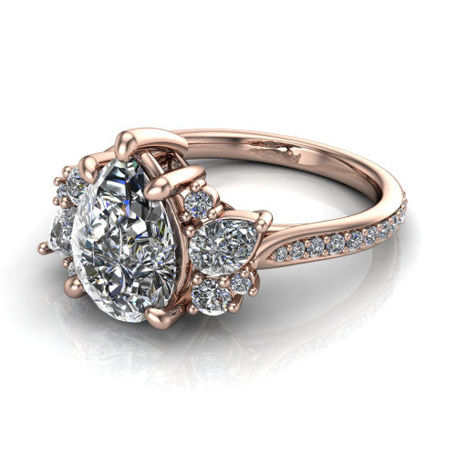 Mila pear three stone engagement ring in 18K Rose Gold, three-quarter perspective showing the center diamond flanked by round accent clusters above a pav&eacute; shank