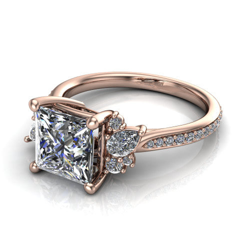 Mila princess three stone engagement ring in 14K Rose Gold, three-quarter perspective showing the center diamond flanked by round accent clusters above a pav&eacute; shank