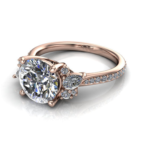 Mila round three stone engagement ring in 18K Rose Gold, three-quarter perspective showing the center diamond flanked by round accent clusters above a pav&eacute; shank