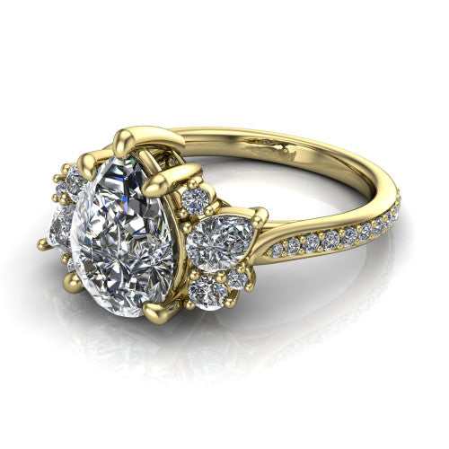 Mila pear three stone engagement ring in 14K Yellow Gold, three-quarter perspective showing the center diamond flanked by round accent clusters above a pav&eacute; shank