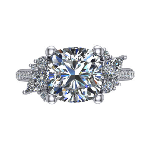 Mila cushion three stone engagement ring in Platinum, top-down view showing the center diamond between two trios of round accent diamonds