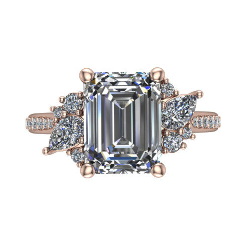 Mila emerald three stone engagement ring in 14K Rose Gold, top-down view showing the center diamond between two trios of round accent diamonds