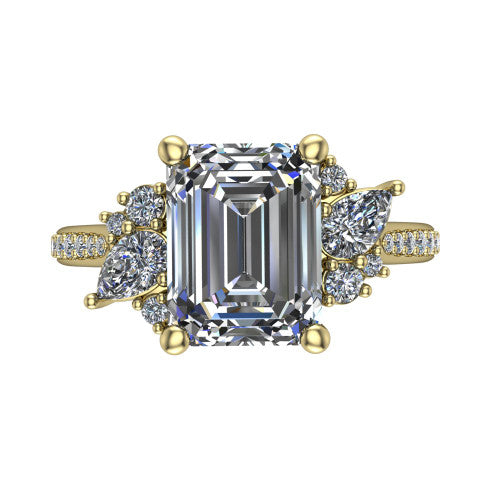 Mila emerald three stone engagement ring in 18K Yellow Gold, top-down view showing the center diamond between two trios of round accent diamonds