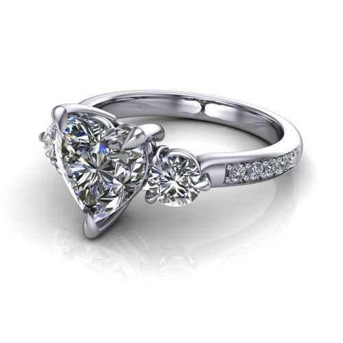 Blake heart three stone engagement ring in Platinum, three-quarter perspective showing the center diamond between two round side stones above a pav&eacute; shank