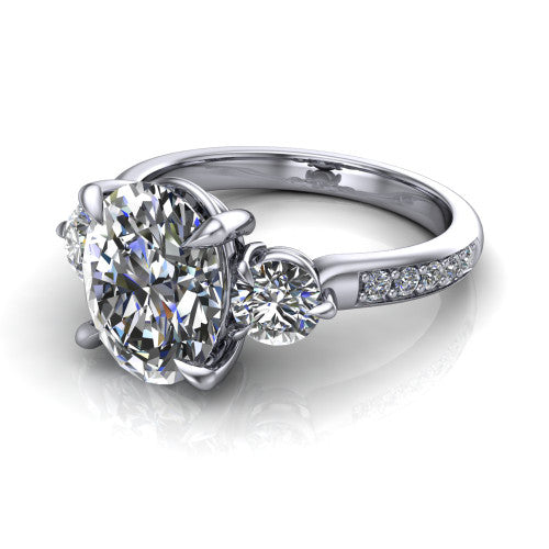 Blake oval three stone engagement ring in Platinum, three-quarter perspective showing the center diamond between two round side stones above a pav&eacute; shank