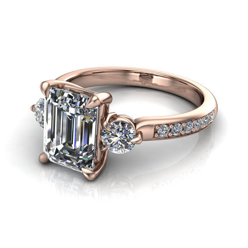 Blake emerald three stone engagement ring in 14K Rose Gold, three-quarter perspective showing the center diamond between two round side stones above a pav&eacute; shank