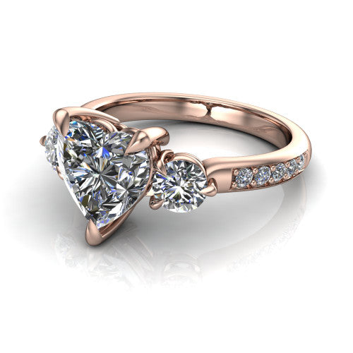 Blake heart three stone engagement ring in 14K Rose Gold, three-quarter perspective showing the center diamond between two round side stones above a pav&eacute; shank