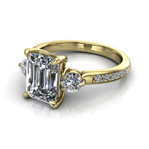 Blake emerald three stone engagement ring in 18K Yellow Gold, three-quarter perspective showing the center diamond between two round side stones above a pav&eacute; shank