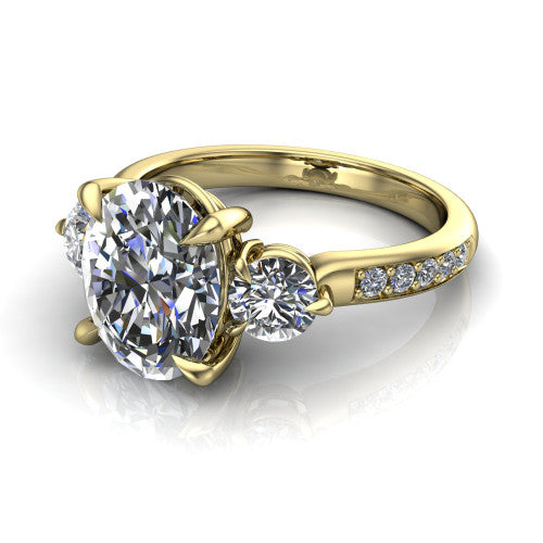 Blake oval three stone engagement ring in 14K Yellow Gold, three-quarter perspective showing the center diamond between two round side stones above a pav&eacute; shank