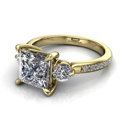 Blake princess three stone engagement ring in 18K Yellow Gold, three-quarter perspective showing the center diamond between two round side stones above a pav&eacute; shank