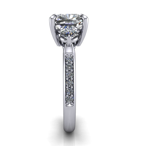 Blake cushion three stone engagement ring in Platinum, side profile showing the round side stone and the pav&eacute; diamonds running down the shank