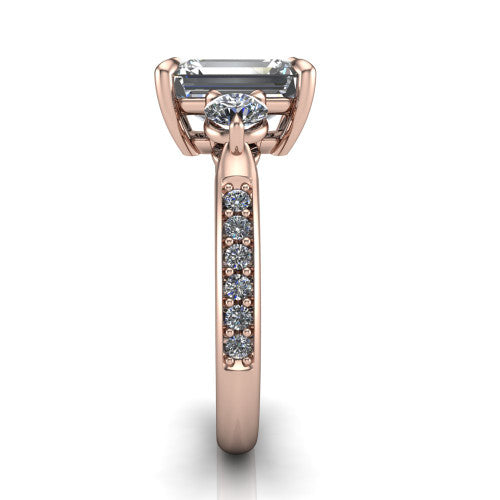 Blake emerald three stone engagement ring in 14K Rose Gold, side profile showing the round side stone and the pav&eacute; diamonds running down the shank