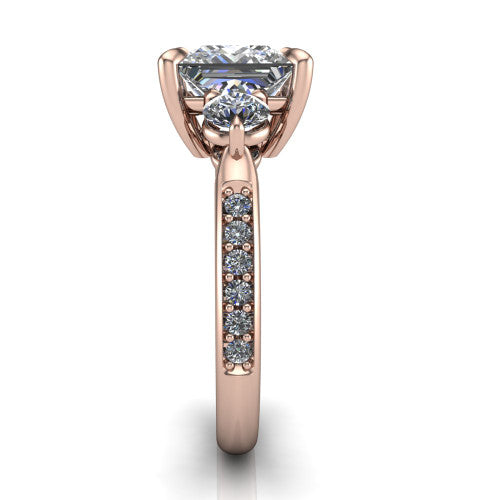 Blake princess three stone engagement ring in 14K Rose Gold, side profile showing the round side stone and the pav&eacute; diamonds running down the shank