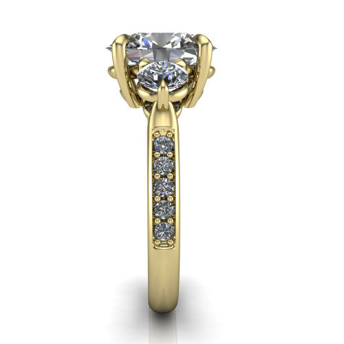 Blake oval three stone engagement ring in 18K Yellow Gold, side profile showing the round side stone and the pav&eacute; diamonds running down the shank