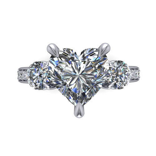 Blake heart three stone engagement ring in Platinum, top-down view showing the center diamond flanked by two round side stones in a classic three stone setting