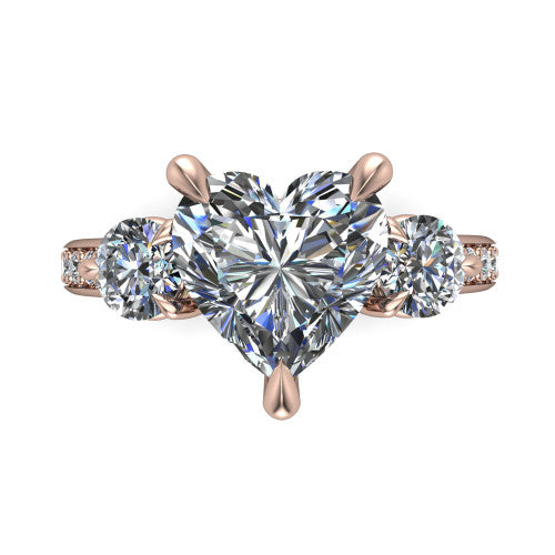 Blake heart three stone engagement ring in 18K Rose Gold, top-down view showing the center diamond flanked by two round side stones in a classic three stone setting