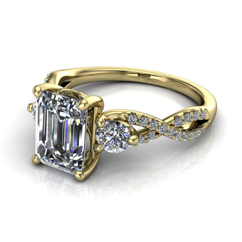 Ryleigh emerald three stone engagement ring in 18K Yellow Gold, three-quarter perspective showing the emerald center between two round side stones above a twisted pav&eacute; band