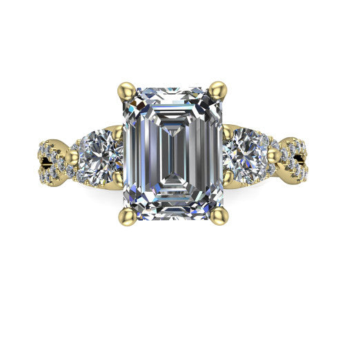 Ryleigh emerald three stone engagement ring in 18K Yellow Gold, top-down view showing the emerald center flanked by two round accent diamonds and the pav&eacute; twist
