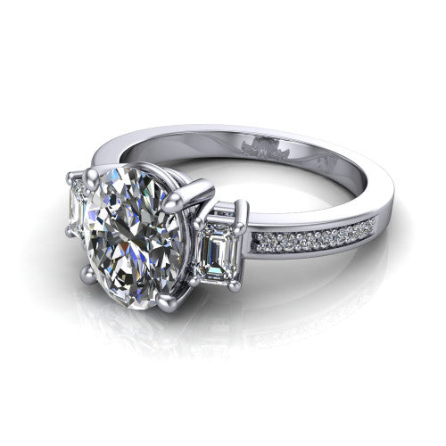 Freya oval three stone engagement ring in Platinum, three-quarter perspective showing the oval center between two emerald cut side stones above a pav&eacute; band