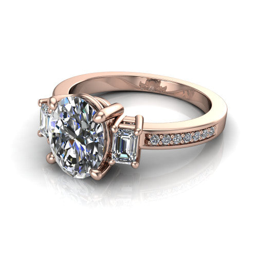 Freya oval three stone engagement ring in 14K Rose Gold, three-quarter perspective showing the oval center between two emerald cut side stones above a pav&eacute; band