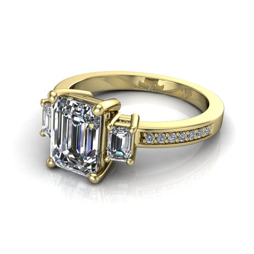 Freya emerald three stone engagement ring in 14K Yellow Gold, three-quarter perspective showing the emerald center between two emerald cut side stones above a pav&eacute; band