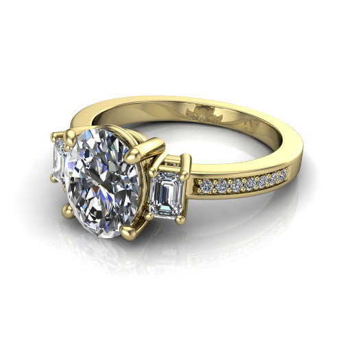 Freya oval three stone engagement ring in 14K Yellow Gold, three-quarter perspective showing the oval center between two emerald cut side stones above a pav&eacute; band