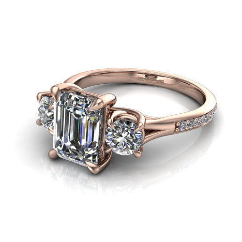 Ruth emerald three stone engagement ring in 14K Rose Gold, three-quarter perspective showing the emerald center between two round side stones above a pav&eacute; band