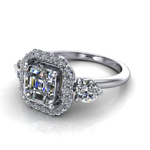 Carol square emerald three stone halo engagement ring in 18K White Gold, three-quarter perspective showing the square emerald center in a squared pav&eacute; halo flanked by two round side stones above a plain band