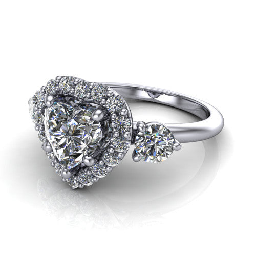 Carol heart three stone halo engagement ring in 18K White Gold, three-quarter perspective showing the heart center in a squared pav&eacute; halo flanked by two round side stones above a plain band