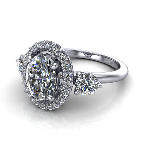 Carol oval three stone halo engagement ring in 14K White Gold, three-quarter perspective showing the oval center in a squared pav&eacute; halo flanked by two round side stones above a plain band