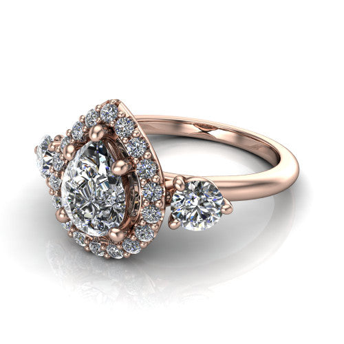 Carol pear three stone halo engagement ring in 18K Rose Gold, three-quarter perspective showing the pear center in a squared pav&eacute; halo flanked by two round side stones above a plain band
